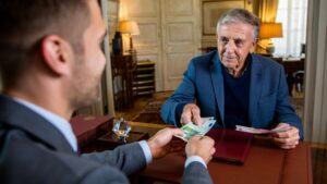 Älterer Mann überreicht Geld